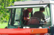 Blick durch Heckscheibe eines Traktors auf zwei Männer in Fahrerkabine