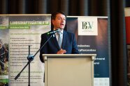 Mann steht an Rednerpult