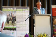 Mann steht an Rednerpult