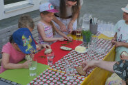 Kinder sitzen an Tisch mit Schnittlauchbroten