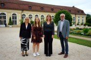 4 Personen stehen auf einem Weg im Freien