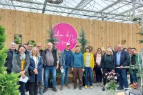 Viele Leute stehen im Halbkreis in der Gärtnerei