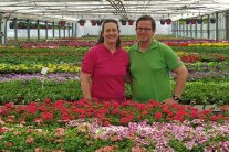 Maren und Dieter Radloff zwischen Blumen in Gewächshaus