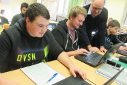 Schüler und Lehrer arbeiten mit Laptops